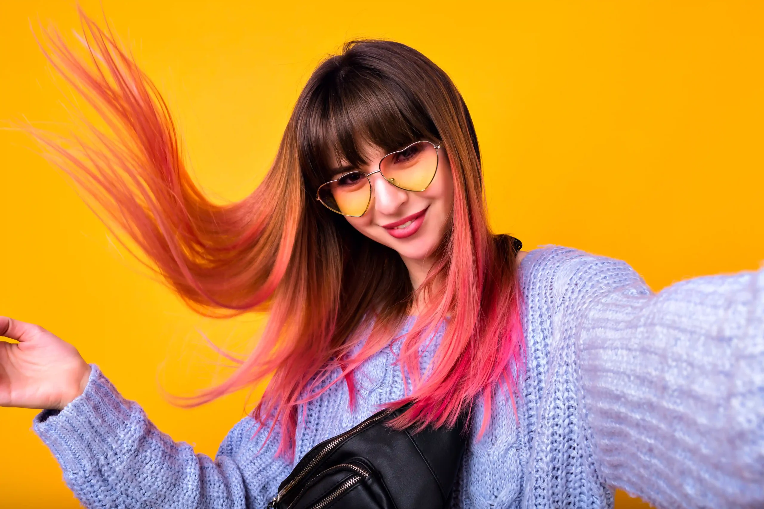 happy-woman-with-unusual-pink-hairs-making-selfie-yellow-wall-stylish-cozy-sweater-hearted-vintage-sunglasses